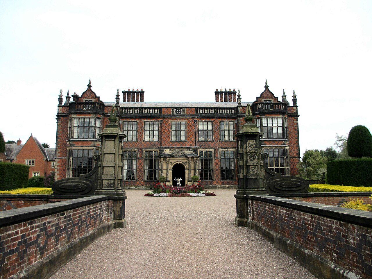 Arley Hall's forecourt and front, seen past stone gate piers