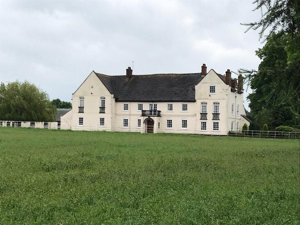 The white-painted house at The Parkes, Audlem, across an open field