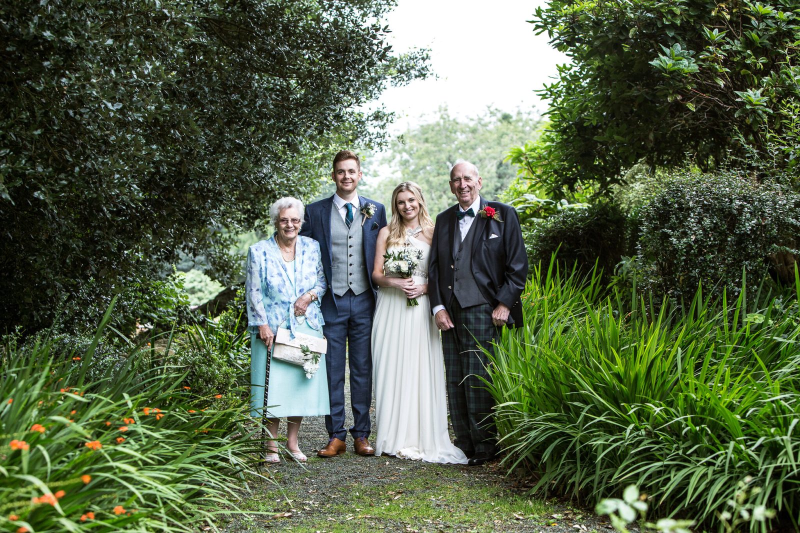 A couple with older relatives in a green garden