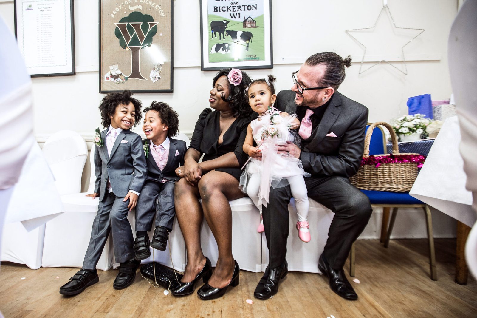 A family with young children sit together on a sofa