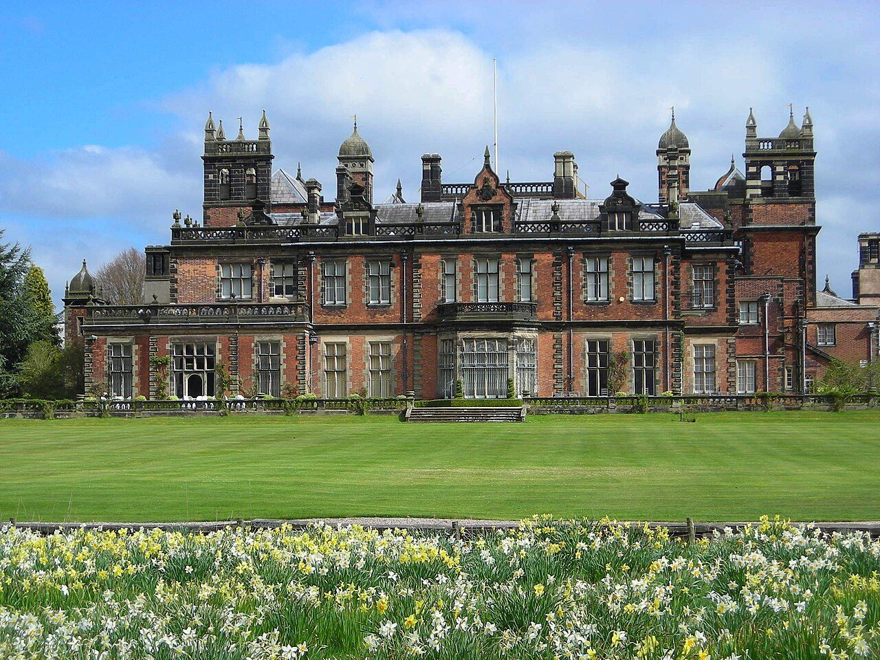 Capesthorne Hall above a lawn of spring daffodils