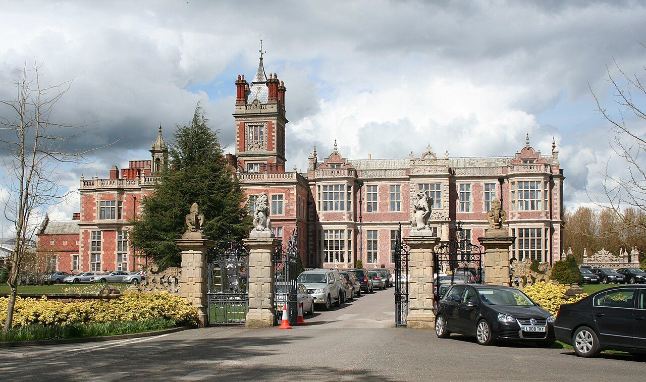 Crewe Hall's red-brick Jacobean front seen through its ornate entrance gates