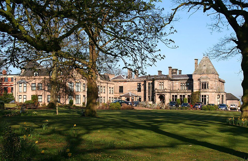 Rookery Hall seen across its lawn beneath mature trees