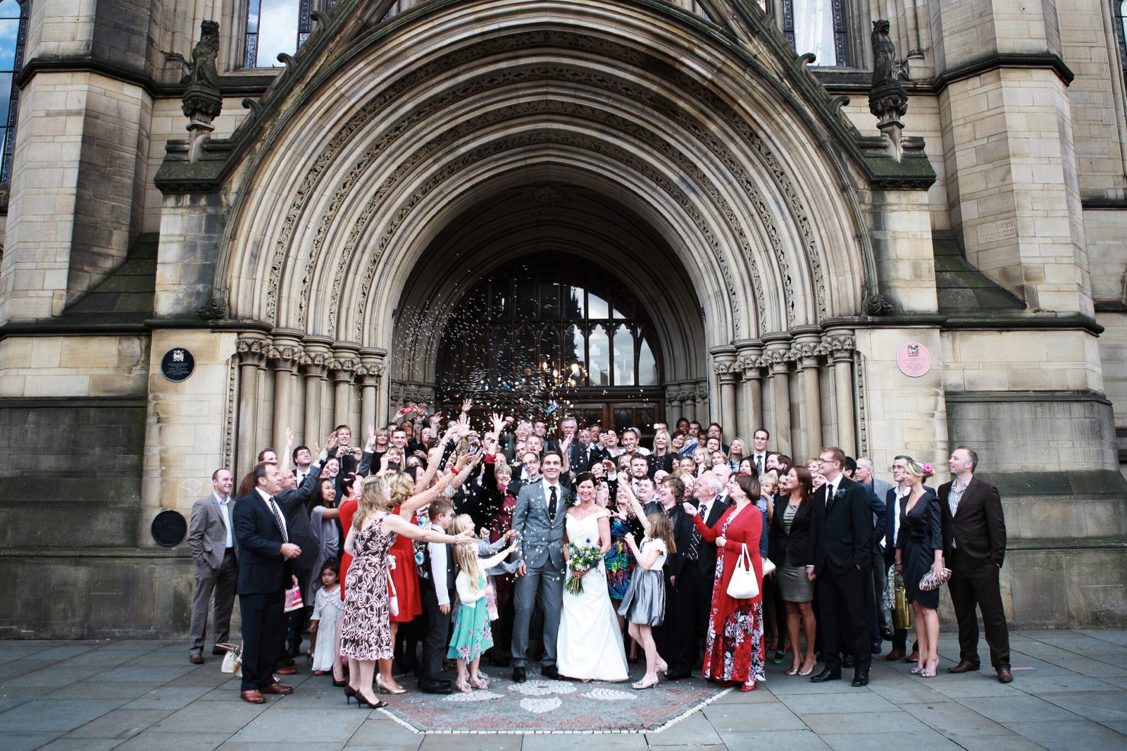 A large group of guests gathered under a church archway